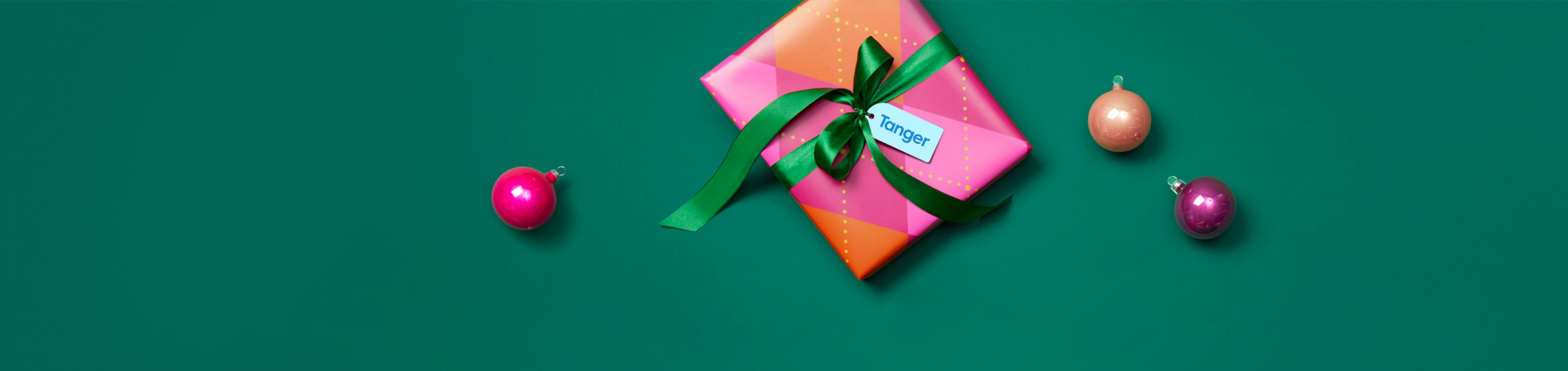 Christmas gift and ball ornaments against a green background