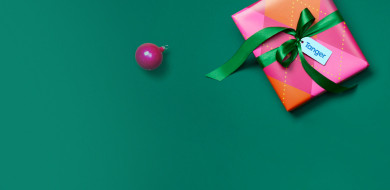 Christmas gift and ball ornaments against a green background